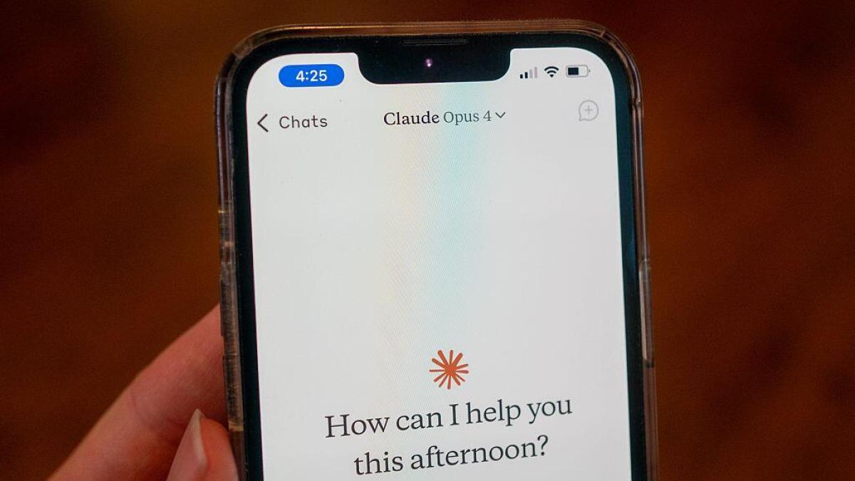 A woman holds up a phone with the Claude Opus 4 AI model running. The screen shows the Claude icon and reads, "How can I help you this afternoon?"